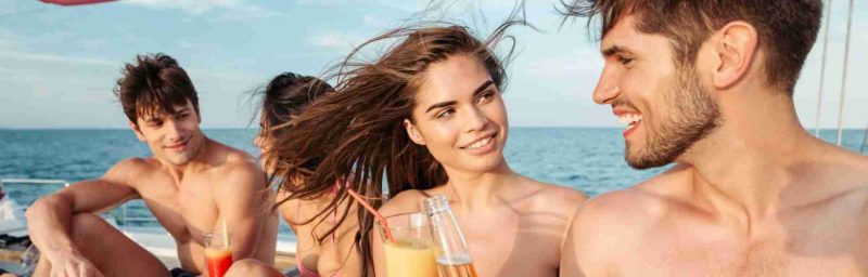 Group of friends drinking and having party on sailing boat